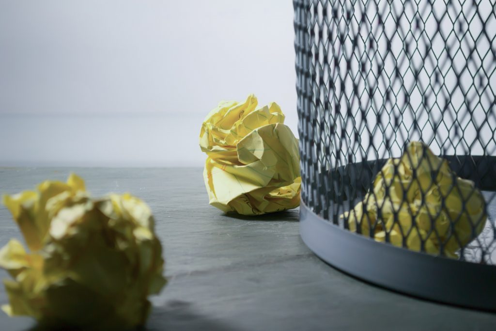 balls of yellow paper rejected wastebasket